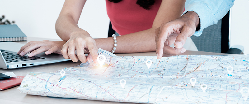 Immagine illustrativa di come si costruisce un piano di marketing territoriale: mappa, computer, ufficio.